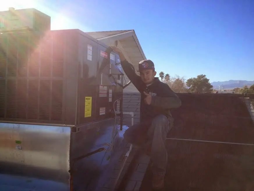 HVAC technician performing HVAC Inspection on a rooftop unit in Norton Shores